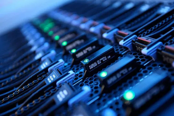 Close-up of server blades with green status lights in a data centre rack