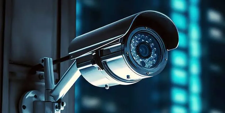 Gros plan d’une caméra de surveillance tube fixée devant une ville la nuit