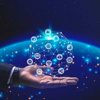 Hand holding a glowing network sphere of technology icons above the earth at night